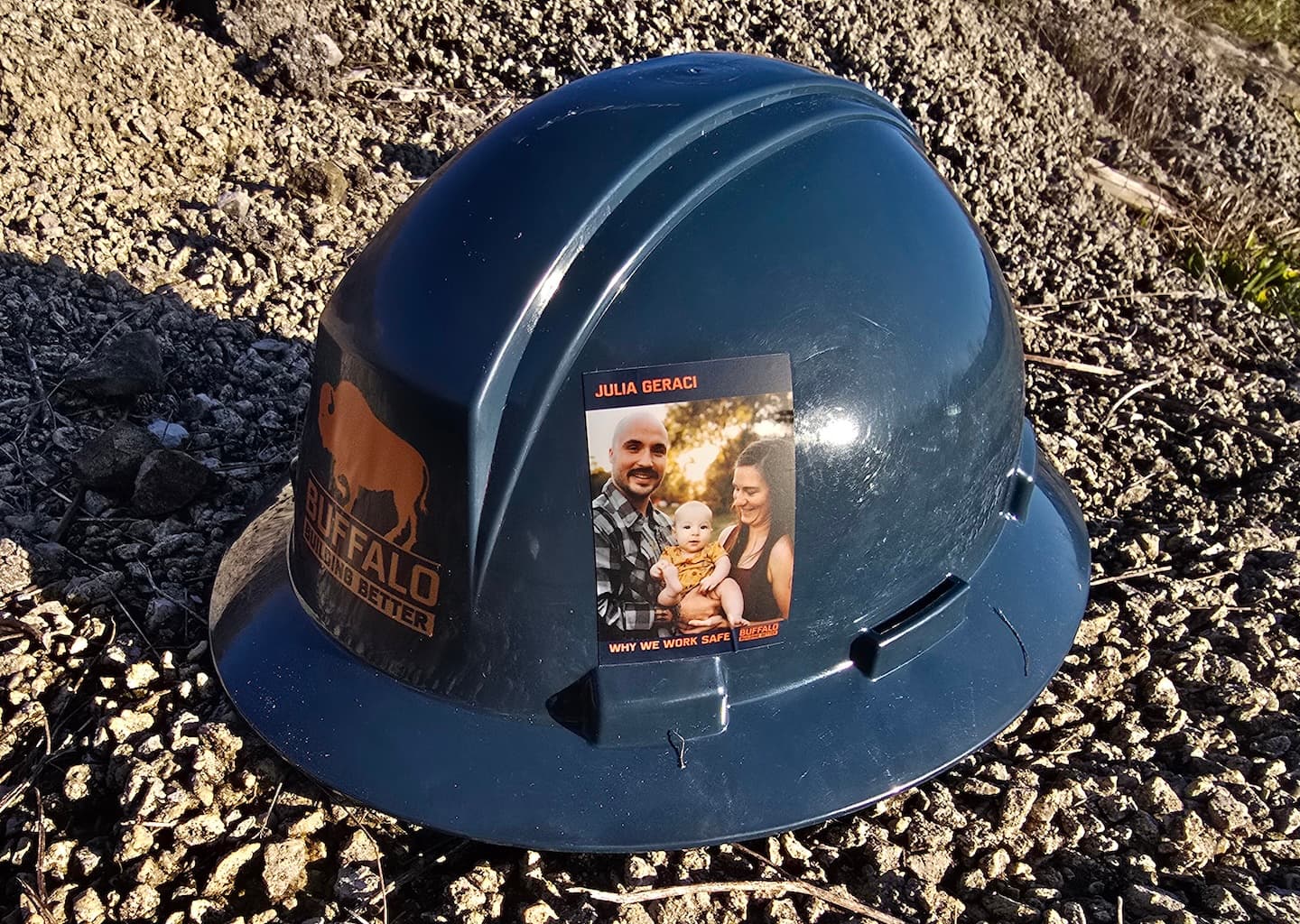 Buffalo hard hat with a sticker of a couple holding a baby